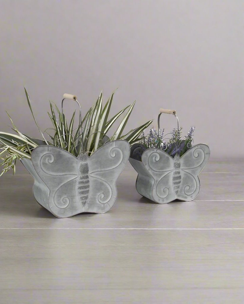 Beautify your home in style with our Nested Butterfly Metal Planter w/Handle - Set of 2. Crafted from zinc for strength &amp; durability, suitable for outdoor as well as indoor use. Features a set of 2 identical but different-sized butterfly planters with hollowed-out space for plants. 

Features:

A beautiful eye-catching statement
Handles to carry the planters
Suitable for indoor as well as outdoor use
Made up of durable material
Colour: Distressed Grey
Material: 100% Zinc
Dimensions: L: 37.5X17X29.5  S: 30.5