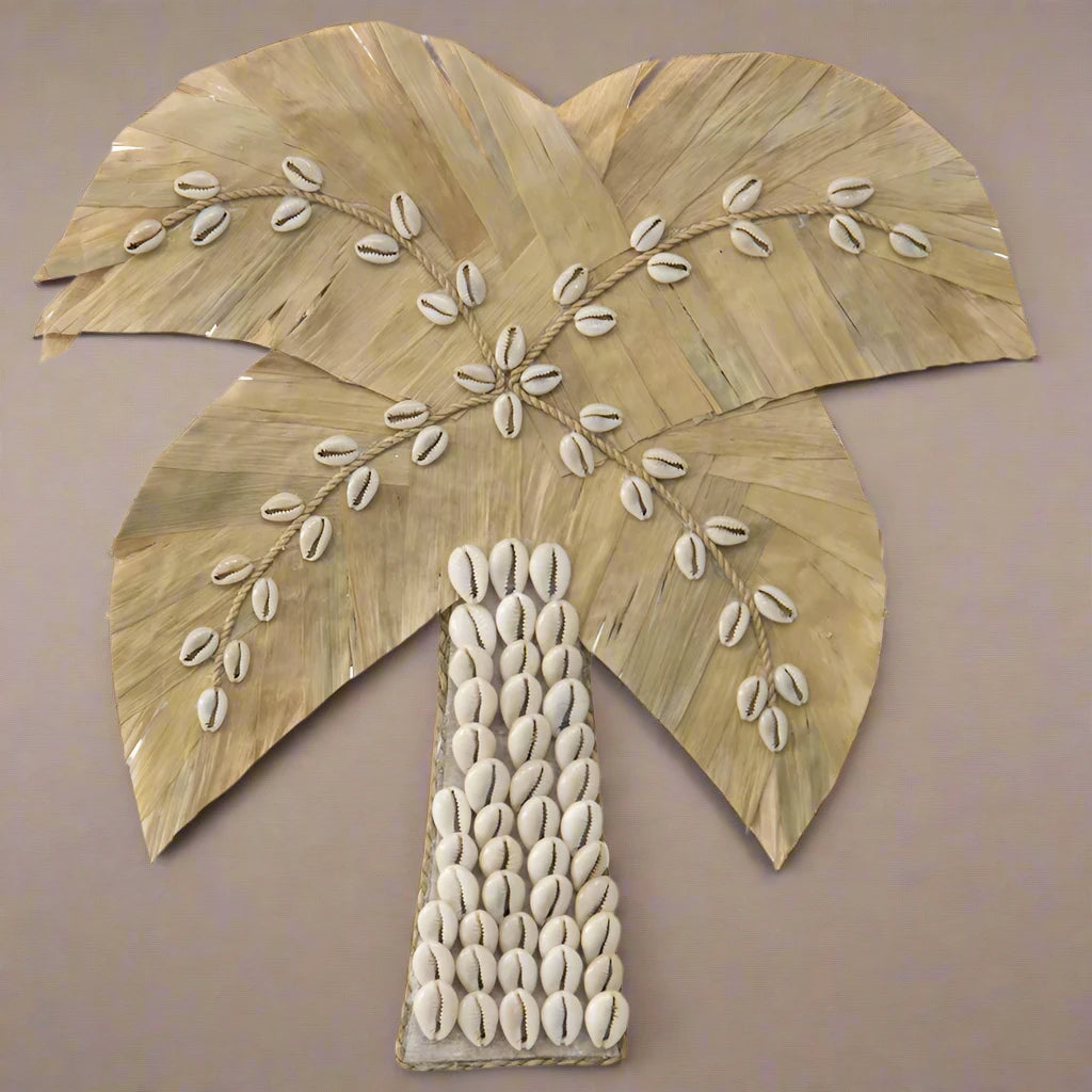 Bring coastal charm into your home with this meticulously crafted Handmade Shell &amp; Weave Palm Tree Wall Art. The artistry behind each detail makes this piece a stunning focal point for any room. A perfect blend of nature-inspired elegance and handmade craftsmanship.

Features:

Delicate seashells &amp; intricately woven leaves
Coastal attraction with handmade artistry
Decorate it in any of the rooms
Colour: White, Natural
Material: Pandan Leaves 50%, Shell 50%
Dimensions: 30x1x30cm