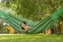 Woman relaxing in a green hammock under a tree
